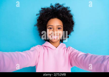 Foto della gioventù bella ragazza tiro selfie vacanza video registrazione blogging isolato su sfondo blu Foto Stock