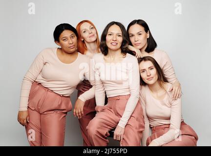 Gruppo di diverse e amichevoli donne multietniche che si levano in piedi insieme e guardano la macchina fotografica Foto Stock