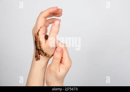 Scrub di caffè sulle mani delle donne, cura della pelle del corpo e delle mani, scrubbing e pilling, un posto per il testo Foto Stock