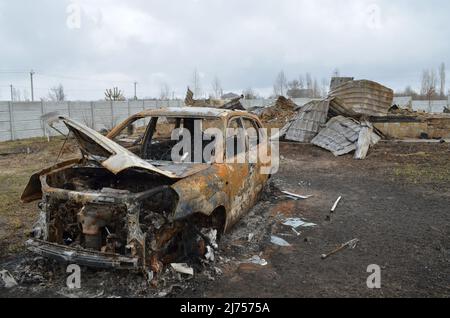 Villaggio di Myla, regione di Kyiv, Ucraina - Apr 03, 2022: Auto e una casa privata completamente bruciati dagli occupanti russi a causa di shelling. Foto Stock