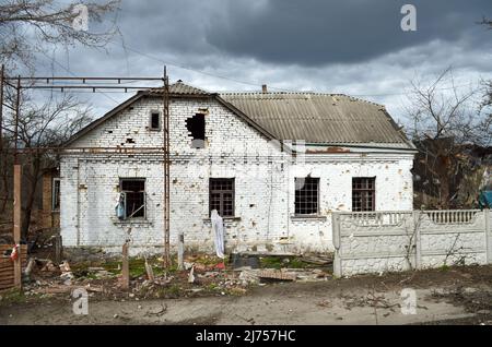 Villaggio di Myla, regione di Kyiv, Ucraina - Apr 11, 2022: Casa danneggiata vicino all'autostrada di Zhytomyr nella regione di Kyiv a causa dell'invasione russa. Foto Stock