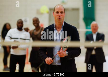 Il Duca di Cambridge gioca a badminton durante una visita allo Sports Key, presso il Doug Ellis Sports Center di Birmingham, che offre attività alla comunità per migliorare il benessere, la coesione e le opportunità di vita delle persone svantaggiate. Data foto: Venerdì 6 maggio 2022. Foto Stock