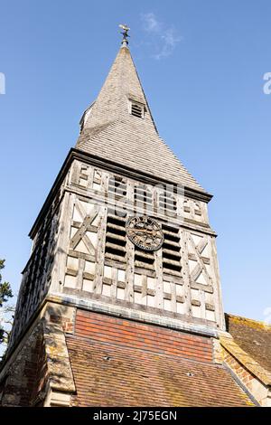 Guardando verso l'alto la guglia di ghiaia e la torre dell'orologio con struttura a legno della chiesa di St Marys, Bromsberrow, Gloucestershire, Inghilterra Regno Unito Foto Stock