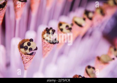 Dessert di festa serviti in coni gelato Foto Stock