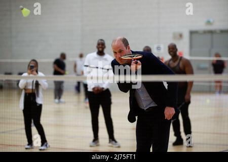 Il Duca di Cambridge gioca a badminton durante una visita allo Sports Key, presso il Doug Ellis Sports Center di Birmingham, che offre attività alla comunità per migliorare il benessere, la coesione e le opportunità di vita delle persone svantaggiate. Data foto: Venerdì 6 maggio 2022. Foto Stock