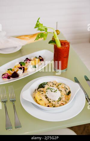 Brunch francese di Tartiflette, insalata di barbabietole e Bloody Mary Foto Stock