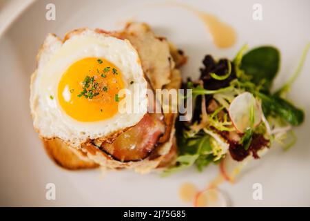 Croque Madame (pane tostato con prosciutto secco, formaggio alla griglia e un uovo fritto) Foto Stock