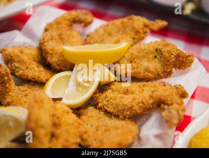 Gamberi fritti in pangrattato serviti con spicchi di limone Foto Stock