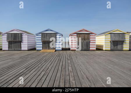 Capanne colorate sulla spiaggia su un molo Foto Stock