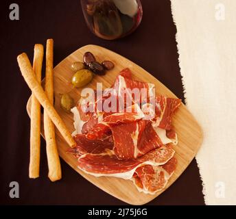 prosciutto e con olive, bastoncini di pane e vino Foto Stock