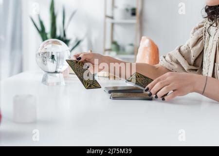 KIEV, UCRAINA - 23 FEBBRAIO 2022: Vista ritagliata delle carte tarocchi di media tenuta in casa Foto Stock