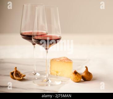 Due bicchieri di vino rosso con formaggio e fichi Foto Stock