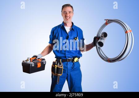 Ritratto di idraulico in uniforme con utensili da lavoro in mano e sfondo isolato blu a gradiente. Vista frontale. Composizione orizzontale. Foto Stock