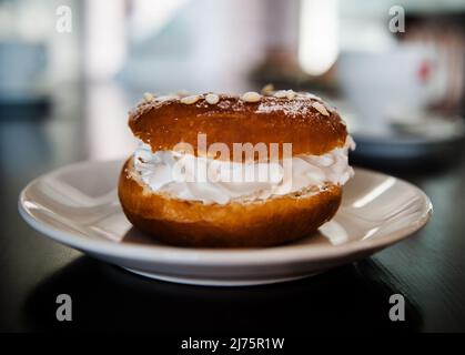 Ciambella glassata con panna montata e zucchero a velo Foto Stock