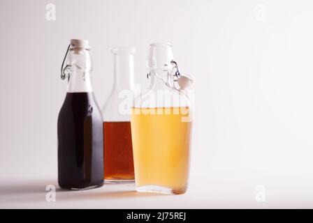 Bottiglia di olio d'oliva con due bottiglie di aceto assortito Foto Stock