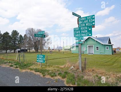 Un cartello stradale nel piccolo villaggio di Fort Rock, Oregon, che indica la strada per varie attrazioni locali. Foto Stock