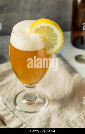 Cocktail Shandy con birra rinfrescante e boozy con una guarnitura al limone Foto Stock