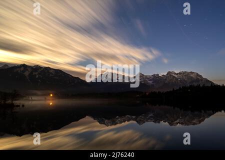 Esposizione notturna delle nuvole in autunno, con i monti Karwendel riflessi nelle acque limpide del Barmsee vicino a Krün. Foto Stock