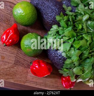 Peperoncino fresco di scotch Bonnet con coriandolo di lime e un avocado ingredienti per fare guacamole Foto Stock