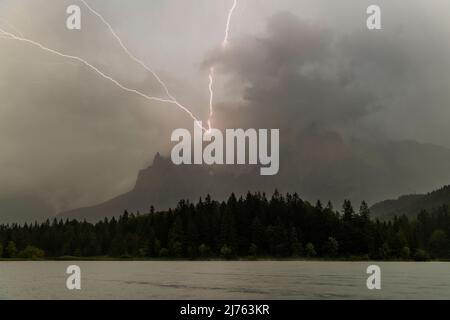 Fulmine al Karwendel sopra Mittenwald nella Karwendelspitze occidentale. In primo piano il Lautersee e la foresta. Foto Stock