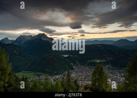 Vista dal rifugio Mittenwald sulla città mercato Mittenwald, i monti Wetterstein e le Alpi in direzione di Garmisch-Partenkirchen alla luce dell'ultima sera Foto Stock