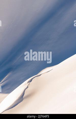 Una duna, o onda di neve e ghiaccio, con luce e ombra sulle pendici del Westliche Karwendelspitze sopra Mittenwald in inverno sole. Foto Stock