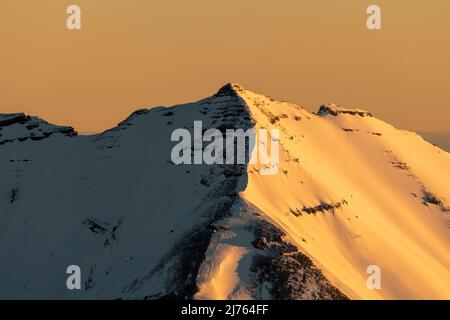 Il Soiernspitze brilla in oro, luce arancione durante l'alba. Preso in inverno con neve e ghiaccio dal Karwendelspitze occidentale sopra Mittenwald. Foto Stock