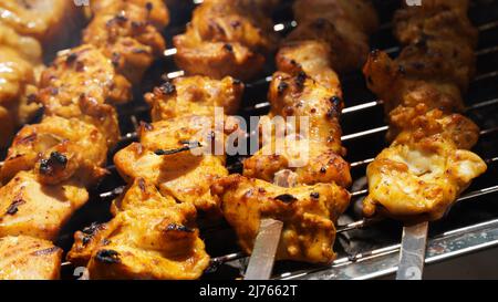 Shashlik - tradizionale barbecue georgiano. Primo piano di carne marinata cruda arrostita barbecue shish kebab shashlik su spiedini di metallo d'acciaio che giacciono fuoco griglia Foto Stock