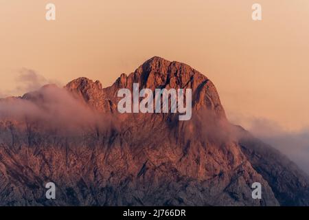 Il picco orientale di Karwendel si illumina di rosso al tramonto, si può vedere un velo di nuvole. Preso dalla cosiddetta Fleischbank. Foto Stock