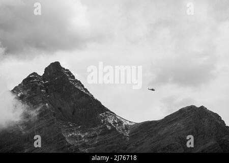 Elicottero che vola attraverso il Karwendel, nelle nuvole di sfondo e la vetta di Kaltwasserkar Foto Stock