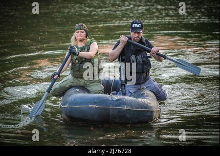 Le forze speciali femminili addestrano nello sbarco barca di gomma che si muove attraverso il fiume. Tiro con le armi da fuoco e allenamento tattico. Foto Stock
