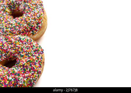 Ciambelle con coloratissimi spruzzi isolati su sfondo bianco. Visualizzazione ad angolo elevato con spazio di copia per il testo. Foto Stock