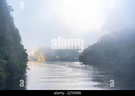 Una nuova mattina che si innamora a Doutful Sound, nuvole che pendono in basso nelle montagne, Isola del Sud della Nuova Zelanda Foto Stock