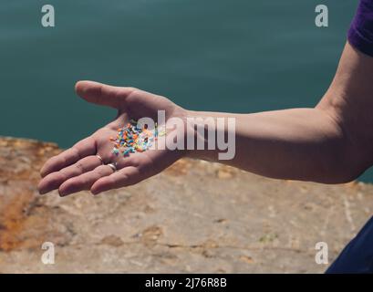 Primo piano di particelle di plastica nelle mani di un volontario. Concetto di inquinamento delle materie plastiche e delle acque. Foto Stock