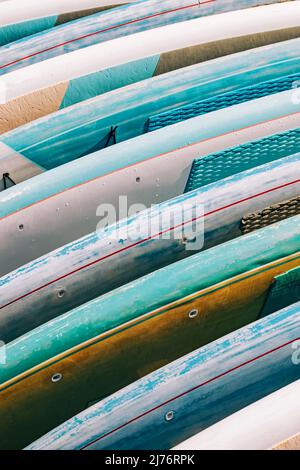 Primo piano di tavole colorate a paddle a noleggio. Attività acquatiche per il tempo libero Foto Stock