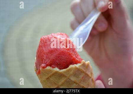 Contiene un cono di waffle freschi con gelato al lampone Foto Stock