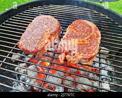 Grigliare le bistecche di manzo sulla griglia a griglia aperta. Foto del processo di cottura della carne o del barbecue. Foto Stock