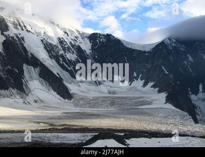 Ghiacciaio Akkem nelle montagne rocciose, Belukha montagna e Akkem parete sullo sfondo di un cielo con le nuvole in estate Foto Stock