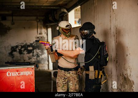 Soldati Airsoft che si aiutano a vicenda nel gioco Foto Stock