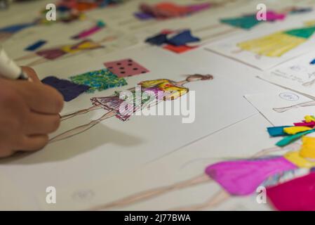 Primo piano di bozzetti di moda sulla scrivania di un designer Foto Stock