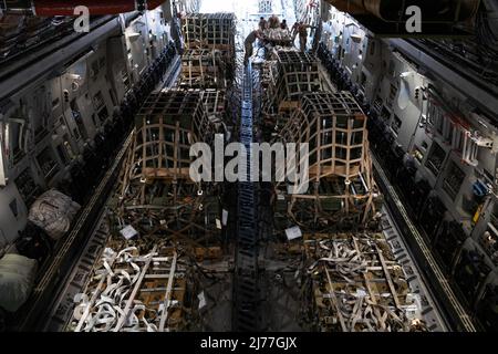 Gli aerei statunitensi spingono un pallet contenente munizioni in un C-17 Globemaster III alla base dell'aeronautica di Travis, California, 28 aprile 2022. Gli Stati Uniti continuano a riaffermare il loro sostegno costante alla sovranità e all’integrità territoriale dell’Ucraina. A sostegno di questa missione, il 60th Aerial Port Squadron trasportò la maggior parte del carico dal 2001 e spostò la maggior parte delle munizioni dalla guerra del Vietnam in un periodo di due settimane. (STATI UNITI Air Force foto di Chustine Minoda) Foto Stock