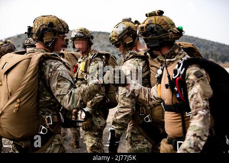 In preparazione per l'esercizio Orion, un Beret Verde dell'esercito degli Stati Uniti assegnato a 10th Gruppo di forze speciali (a sinistra) scambia un primo urto con un membro delle forze speciali di operazioni greche (SOF) prima di addestramento di operazioni aeree alla zona di goccia vicino Elefsina, Grecia, 29 marzo 2022. Exercise Orion rafforza la Grecia come leader del SOF regionale, migliora l'interoperabilità tra più domini e rafforza le relazioni con la NATO e i partner non NATO. L'esercizio è incentrato sull'evidenziazione delle capacità operative, delle collaborazioni internazionali e della formazione in materia di guerra convenzionale e ibrida. (STATI UNITI Esercito foto Foto Stock