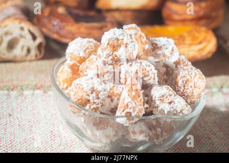 Tradizionale panificio brasiliano tipo dolce chiamato 'Carolina sugary' un adattamento dei profiteroles in una ciotola trasparente con luce morbida. Foto Stock