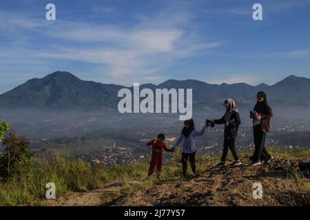 Sumedang, Giava Occidentale, Indonesia. 7th maggio 2022. Le donne hanno scattato una foto con lo sfondo del paesaggio naturale il 7 maggio 2022 a Mount Batu Tanjungsari, Sumedang Regency, Indonesia. Il monte Batu Tanjungsari è una delle destinazioni turistiche per le persone che trascorrono la vacanza Eid al-Fitr 1443 H con le loro famiglie. (Credit Image: © aggi Fabbri Sugita/ZUMA Press Wire) Foto Stock