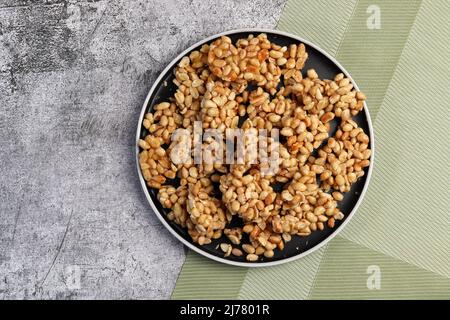 Torta di arachidi fatta in casa su un piatto rotondo su sfondo grigio scuro. Vista dall'alto, piatto Foto Stock