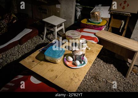 28 aprile 2022, Kharkiv, Kharkiv'ka Oblast'', Ucraina: Un cupcake pasquale e cibo sono visti su un tavolo in un bunker sotterraneo nel sud-est di Kharkiv. I cittadini di Kharkiv sono stati costretti ad adottare una nuova vita sotterranea nei bunker senza elettricità e acqua, poiché la seconda città più grande in Ucraina si trova ora ad affrontare la minaccia costante dei bombardamenti e degli attacchi aerei russi. I cittadini di Kharkiv sono stati costretti ad adottare una nuova vita sotterranea nei bunker senza elettricità e acqua. La seconda città più grande in Ucraina si trova ora di fronte alla costante minaccia dei bombardamenti e degli attacchi aerei russi. (Credito IMA Foto Stock