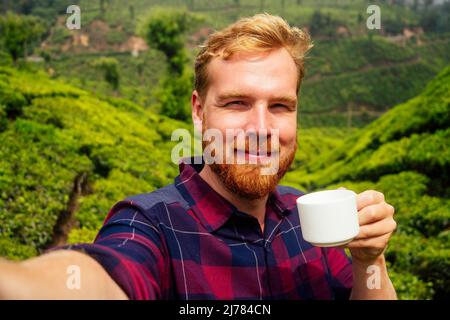 Zenzero rosso maschio godendo mattina in India piantagioni di chai Munnar Foto Stock