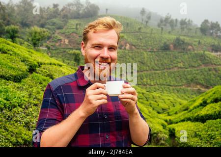 Zenzero rosso maschio godendo mattina in India piantagioni di chai Munnar Foto Stock