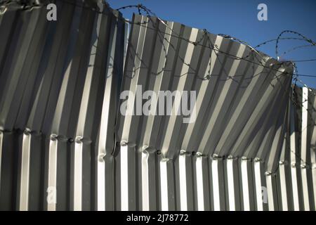 Recinzione rotta. Recinzione da foglio profilo piegato. Ferro frugato. Danni alla recinzione. Foto Stock