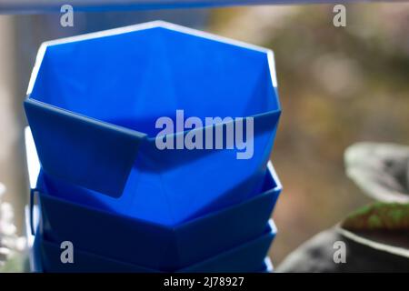 Vasi di fiori blu. Oggetto per pianta crescente. La luce solare cade sulla plastica blu. Dettagli sulle cose sul balcone. Foto Stock